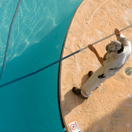 service professional vacuuming pool